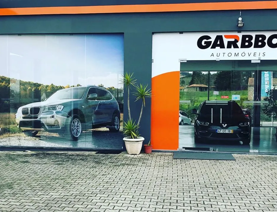 Fachada e montra do stand Garbbo Automóveis decoradas com vinil